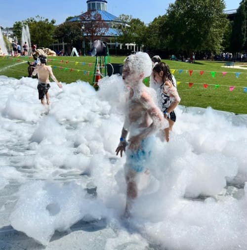 Kids enjoying the foam slide provided by FOC at the Chatt Town Cool Down 2023